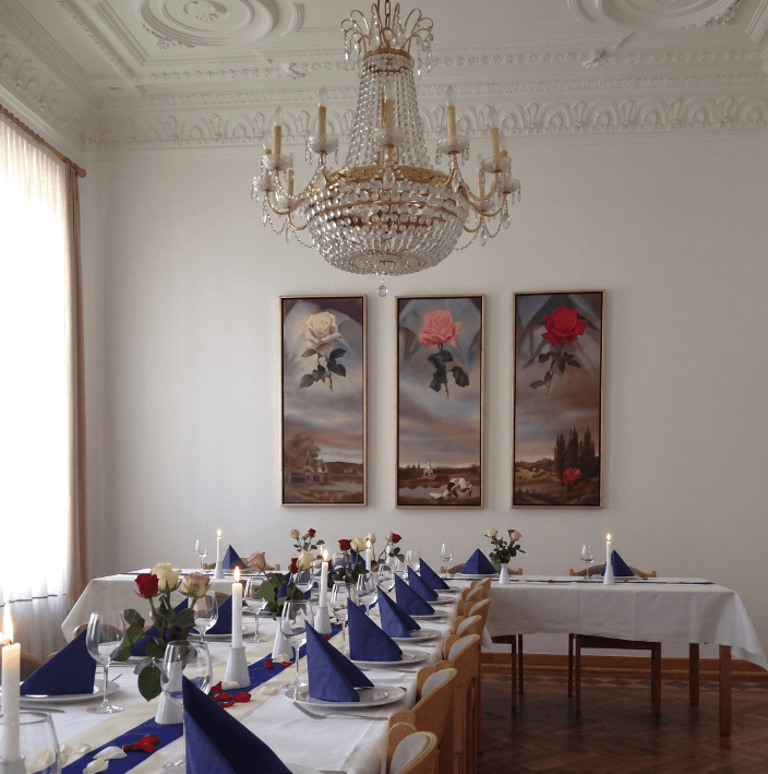 Tafelsaal des Logenhauses mit festlich gedecktem Tisch und Kronleuchter.